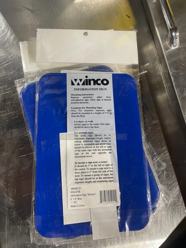 Winco Model SGN-651B blue "Women/Accessible" sign, new condition, adhesive backing, dimensions 7" x 5", includes mounting instructions.