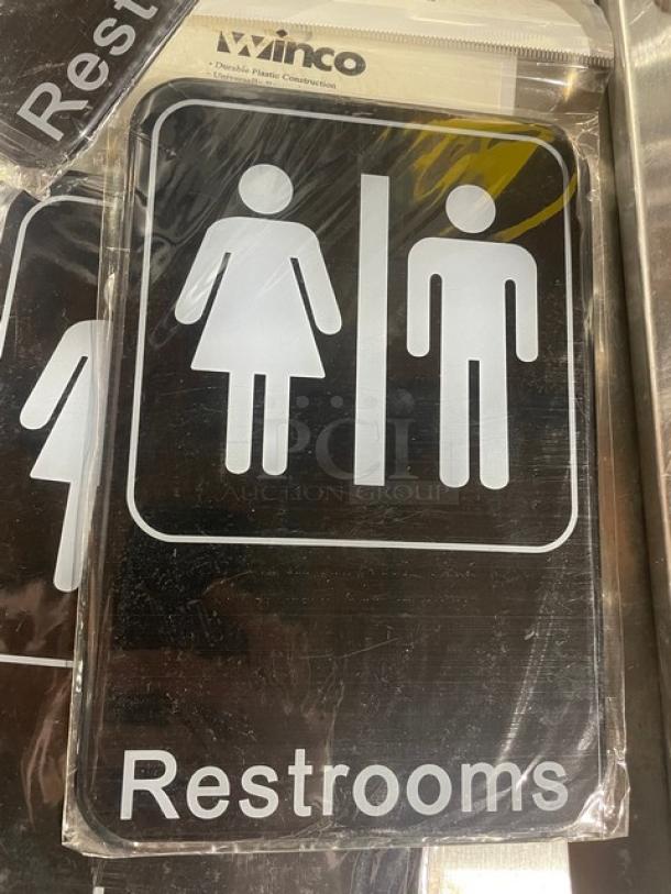 Winco SGN603 black "Restrooms" sign, new condition. Features durable plastic construction, 7" x your bid.