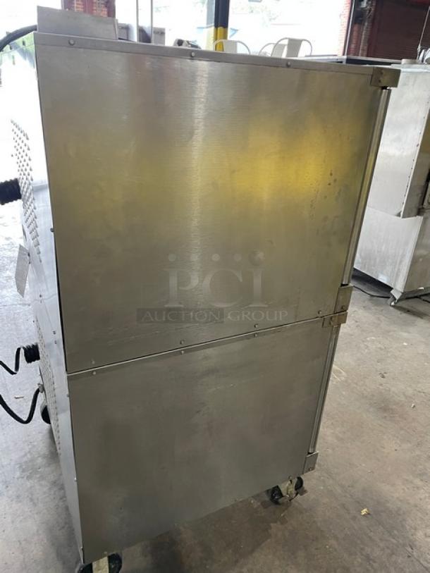 Vulcan commercial stainless steel electric double stacked convection oven on casters, with wired oven racks, side view.
