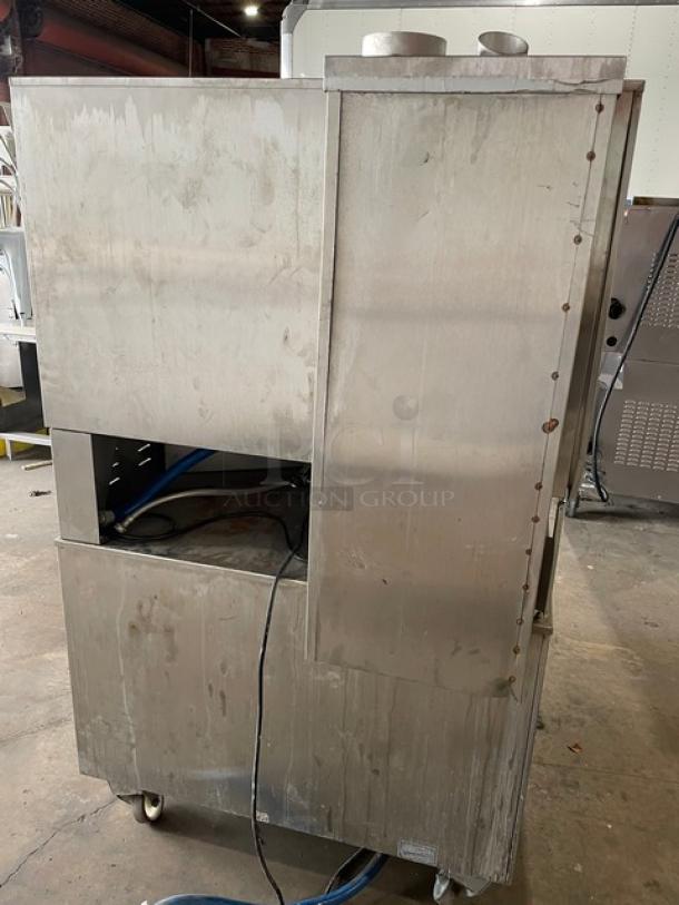 Rational SCC62G commercial double-stacked combi oven, stainless steel, gas-powered, with wired racks, blue gas connector, on casters.