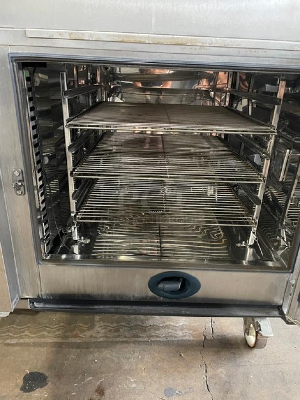Rational SCC62G stainless steel double-stacked combi oven with wired racks, blue gas connector, on casters. Natural gas powered.