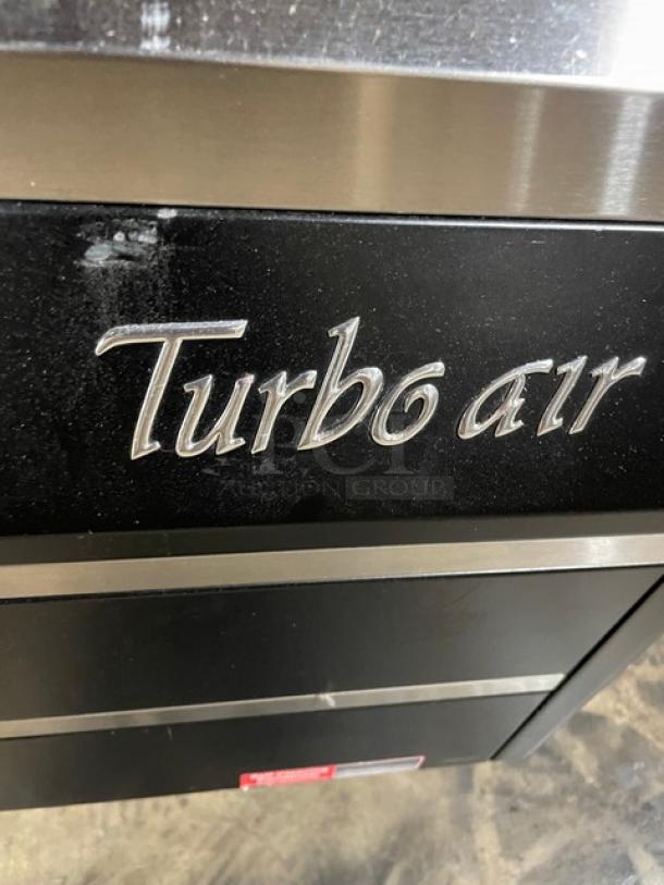 Turbo Air TOM-40MB commercial refrigerated display case, black with stainless steel interior, model and brand name visible.