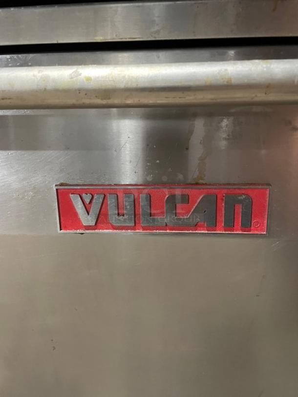 Vulcan stainless steel 10-burner range and double oven combo, with backsplash, salamander shelf, and wired racks.