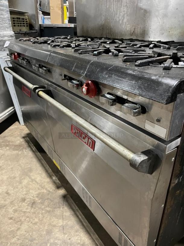 Vulcan commercial stainless steel natural gas 10-burner range and double oven combo, with backsplash, overhead salamander shelf, and wired oven racks. In good condition, on legs.