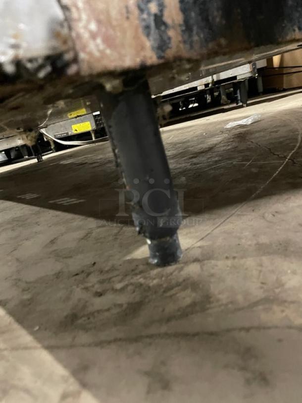 Vulcan range leg detail, showing wear and placement on floor. Part of a 10-burner, double oven combo unit.