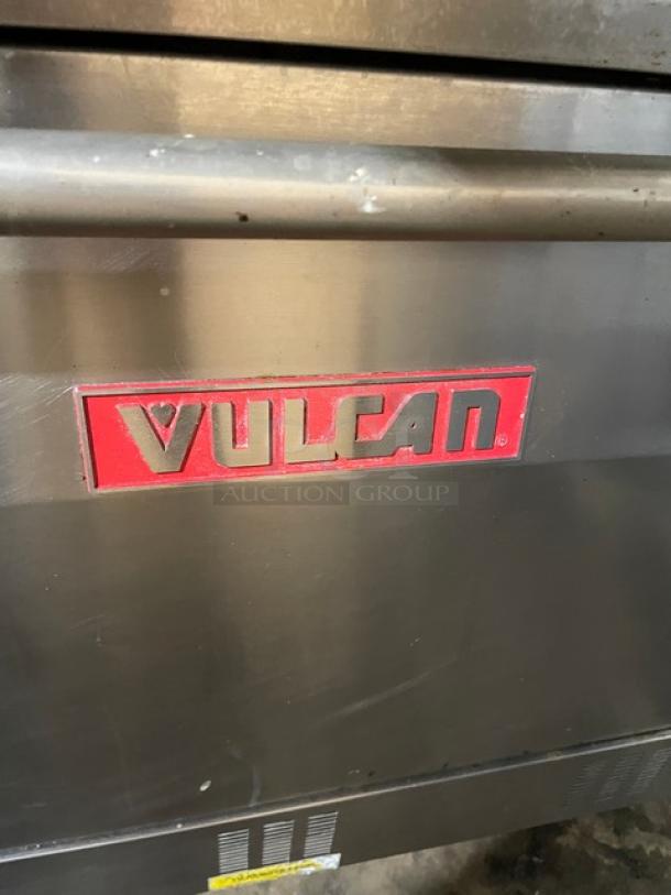 Vulcan commercial stainless steel 6-burner gas range/oven combo with backsplash, overhead salamander shelf, and wired oven rack.