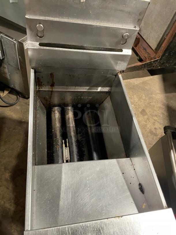 Pitco VF35S stainless steel 35 lb. natural gas fryer with back splash, basket hanger, and blue gas connector hose. On legs.