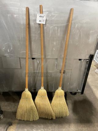 Carlisle Model 3685500 corn blend warehouse brooms, wooden handles, natural fibers. Tags show sizes: 43"x 44"x.