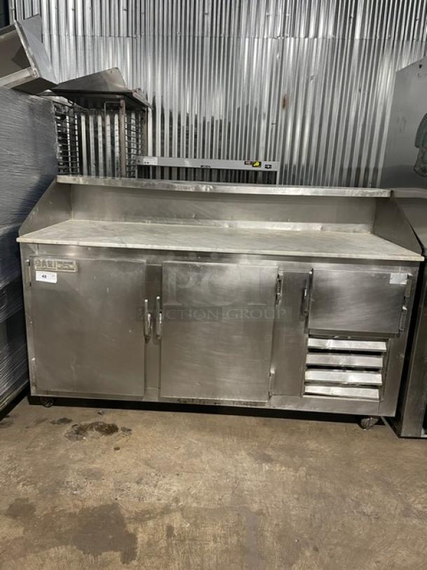 Bari 3-door refrigerated pizza prep table, stainless steel, marble-style worktop, on casters, used condition with visible wear.