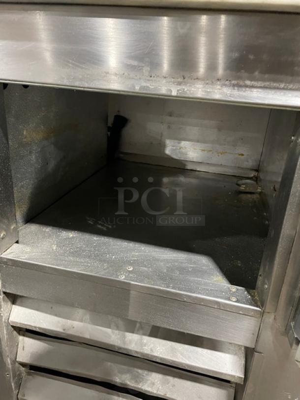 Bari stainless steel 3-door refrigerated pizza prep table, marble style worktop, on casters, interior view.