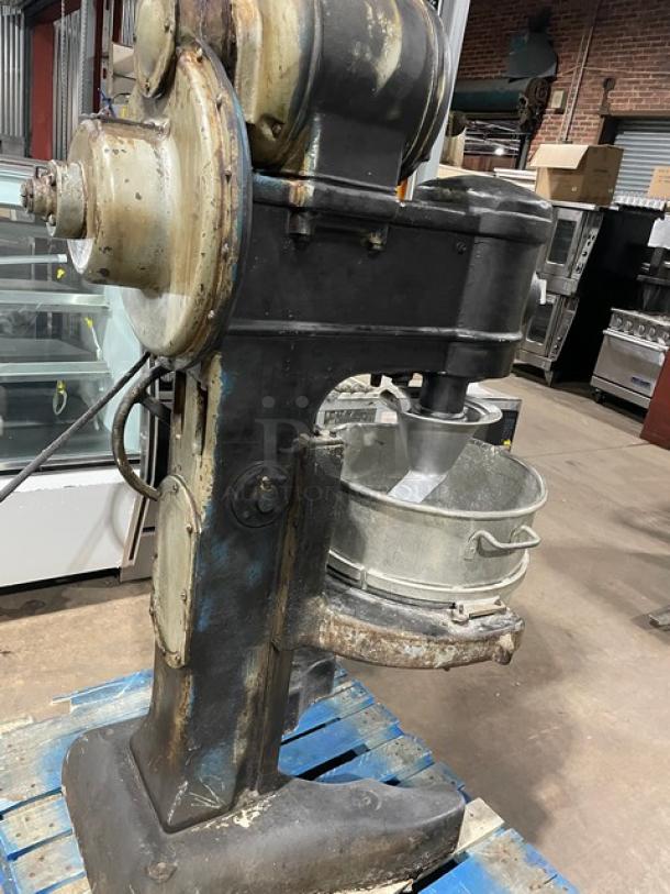 Commercial black heavy-duty planetary mixer with stainless steel bowl and spiral dough hook on legs. Used condition.