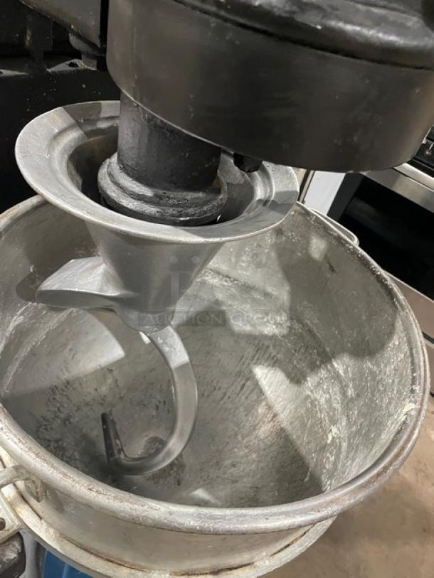 Commercial black electric planetary mixer with a stainless steel bowl and spiral dough hook. Heavy-duty and free-standing.