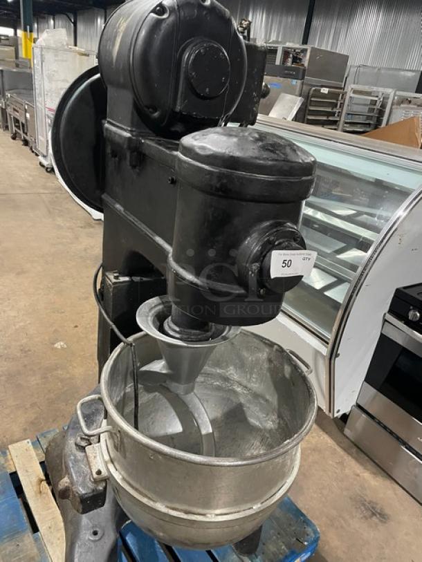 Commercial black planetary mixer with stainless steel bowl, spiral dough hook, heavy-duty, on legs, electric powered.
