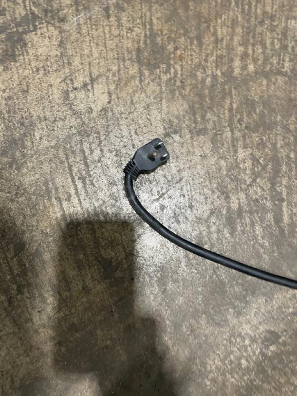 Close-up of Arctic Air AR49E refrigerator power cord; standard 115V plug on textured surface.