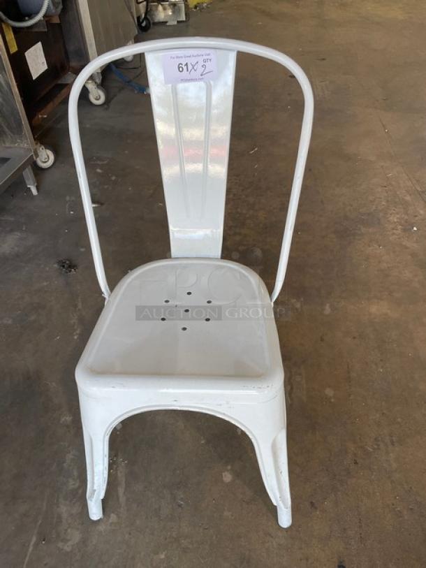 Distressed white indoor-outdoor stackable bistro-style dining chair, metal construction, rustic finish, item tag attached.