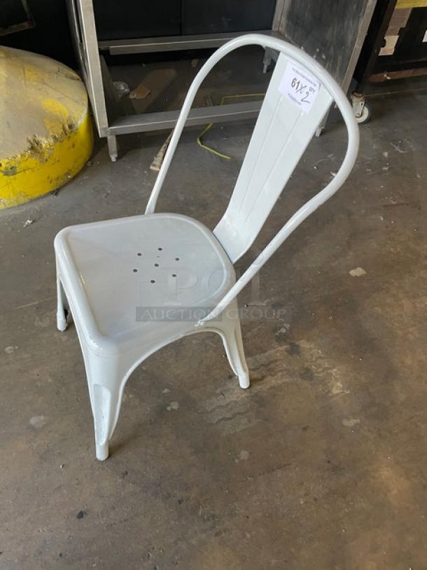Distressed white stackable bistro chair, metal, indoor-outdoor use, perforated seat, auction tag marked "617-2", good condition.