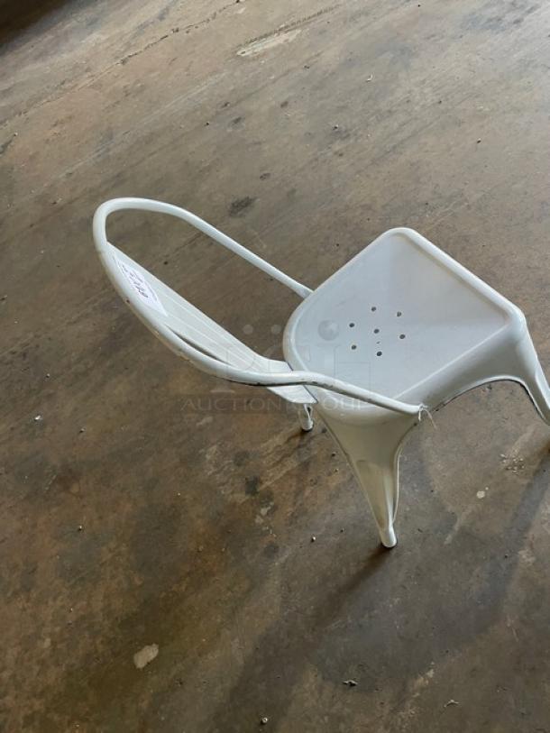 Distressed white stackable bistro chair for indoor-outdoor use; sturdy metal frame with perforated seat. Visible wear.