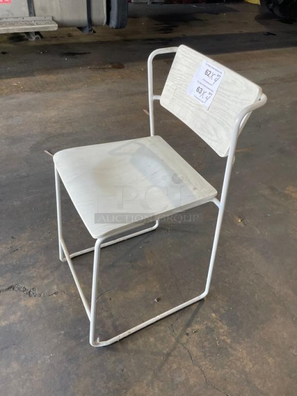 Commercial white wooden-style dining chair with metal frame, stackable, suitable for indoor-outdoor use. Appears in used condition.