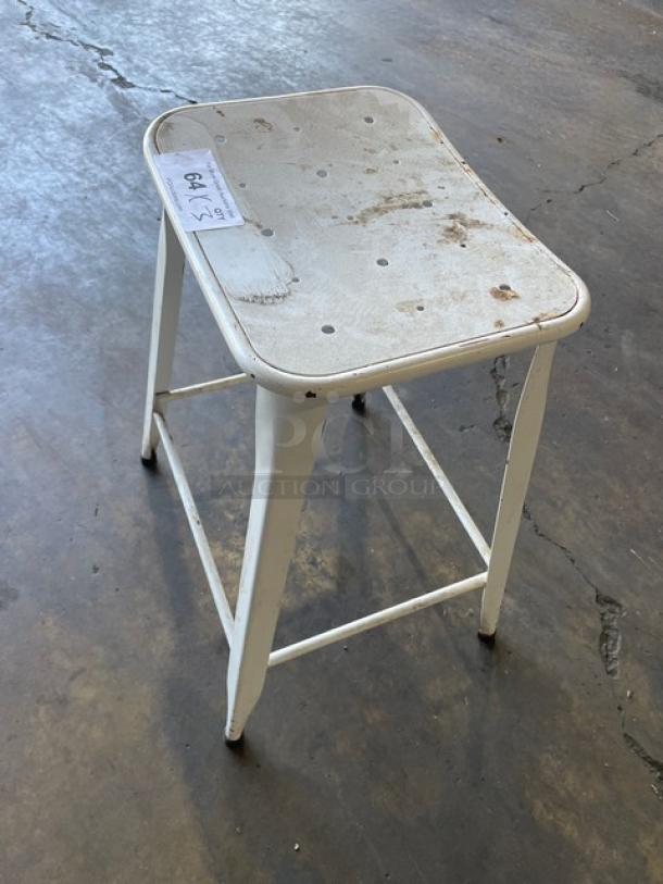 Distressed white metal bar-height stool, suitable for indoor-outdoor use. Features stackable design; shows wear. Tag reads "Lot 470".