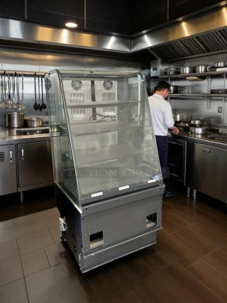 Curved glass bakery display case in excellent condition, fully tested and working, with multiple shelves.