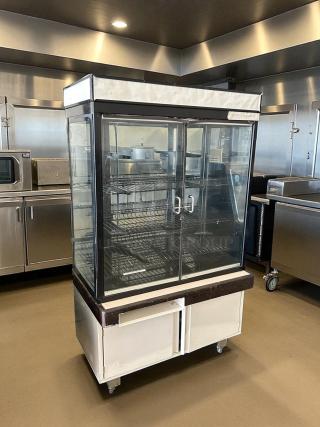 Hussmann dry bakery display case, amazing condition, fully tested, glass doors, metal shelves, on wheels, kitchen setting.
