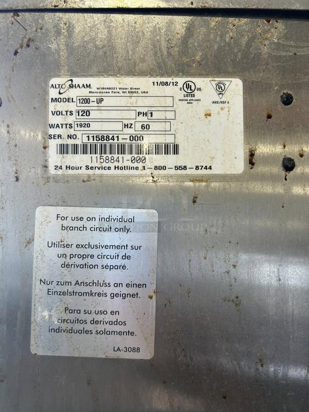 Alto-Shaam 1200-UP tag showing model, voltage, wattage, serial number, and certification details.