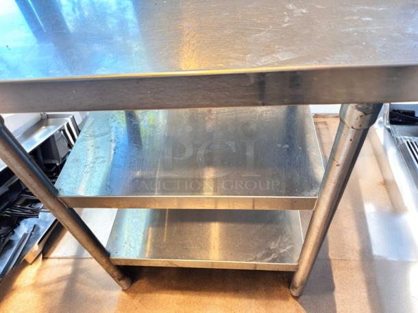 Heavy-duty stainless steel work table with two undershelves, fully tested, durable, ideal for prep and utility tasks.