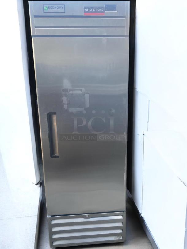 Economy single door stainless steel upright freezer, 115V, tested and working. Features brand labels "Economy" and "Chef's Toys."
