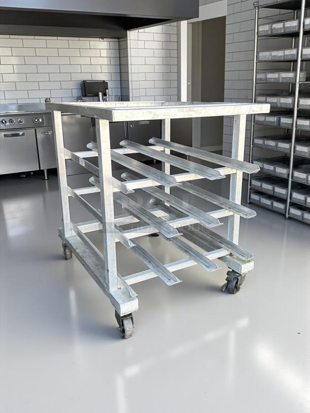 Half size mobile aluminum can rack for #10 and #5 cans in excellent condition, featuring durable construction and casters.