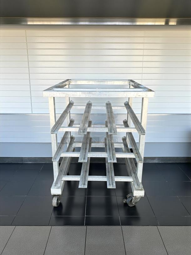 Half-size mobile aluminum can rack for #10 and #5 cans in excellent condition with sturdy wheels and slotted design.
