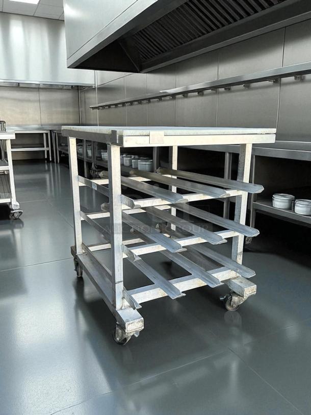 NEW AGE aluminum can rack with poly top cutting board in excellent condition, mobile with casters, for #10 and #5 cans.