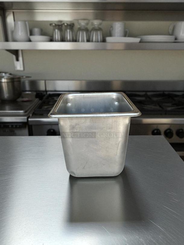 Stainless steel hotel pan, 1/6 size, 6in deep, suitable for prep tables. Appears in good condition, kitchen background.