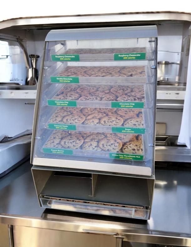 Nemco 6490-SUBA cookie display case, 24"H x 17"W x 12"D, featuring multiple trays with calorie labels, tested and in great condition.