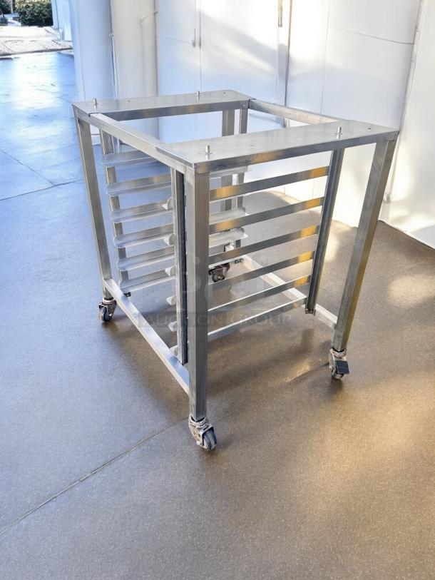 Stainless steel mobile pan rack with casters in excellent condition, tested and working, ideal for equipment storage.