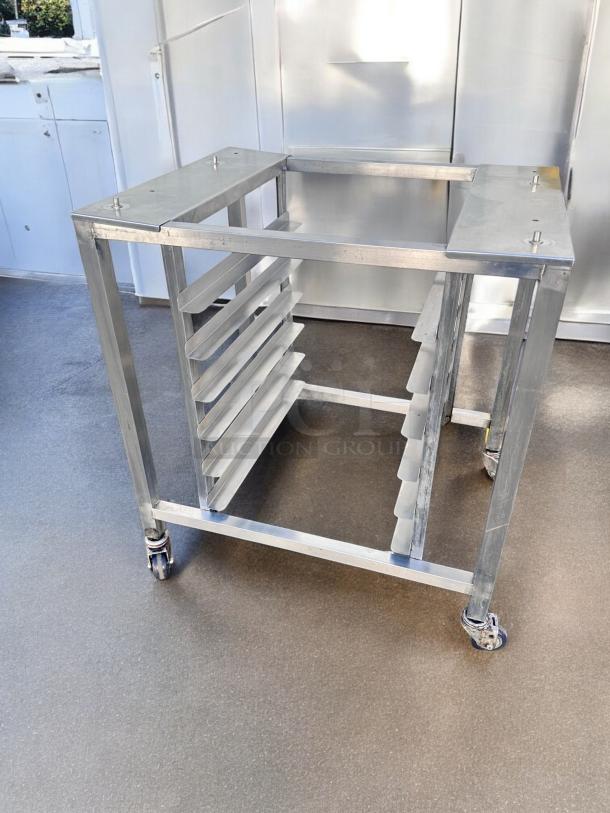 Stainless steel mobile pan rack on casters, excellent condition, equipped with slide-in rails. Ideal for equipment or storage use.