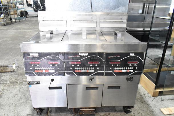 Henny Penny EEG-243 FFFX ST stainless steel 3-bay deep fryer with lids, filtration system, commercial casters, 225,000 BTU.