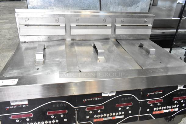 Henny Penny EEG-243 FFFX ST stainless steel 3-bay deep fryer with filtration, lids, and commercial casters. 225,000 BTU.