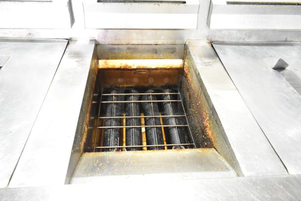 Henny Penny EEG-243 FFFX ST 3-bay deep fryer, stainless steel, natural gas, filtration system, on casters, visible wear.