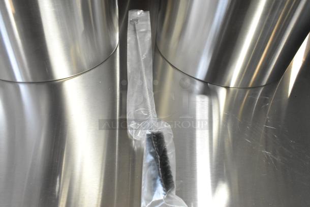 2 new Fetco TPD-30 Luxus stainless steel 3-gallon coffee dispensers, scratch and dent, with cleaning brush in packaging.