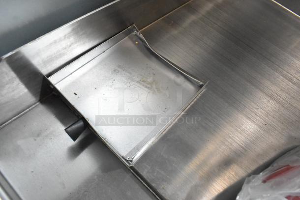 Stainless steel surface of Avantco 177CAG15MG gas griddle. New with scratch and dent, 15" countertop, manual controls.