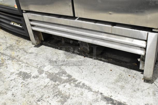 2016 True T-35 stainless steel, 2-door commercial reach-in cooler, poly-coated racks, 115 volts, 1 phase, seen from below.