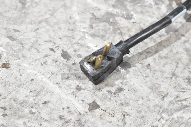 A close-up of a power cord plug against a textured surface, related to the 2018 True T-35-HC cooler.