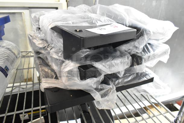 Six brand new Choice Smoke Black Condiment Caddies, model 176NDPLCDYBK, wrapped in plastic on a shelf, for napkin dispensers.