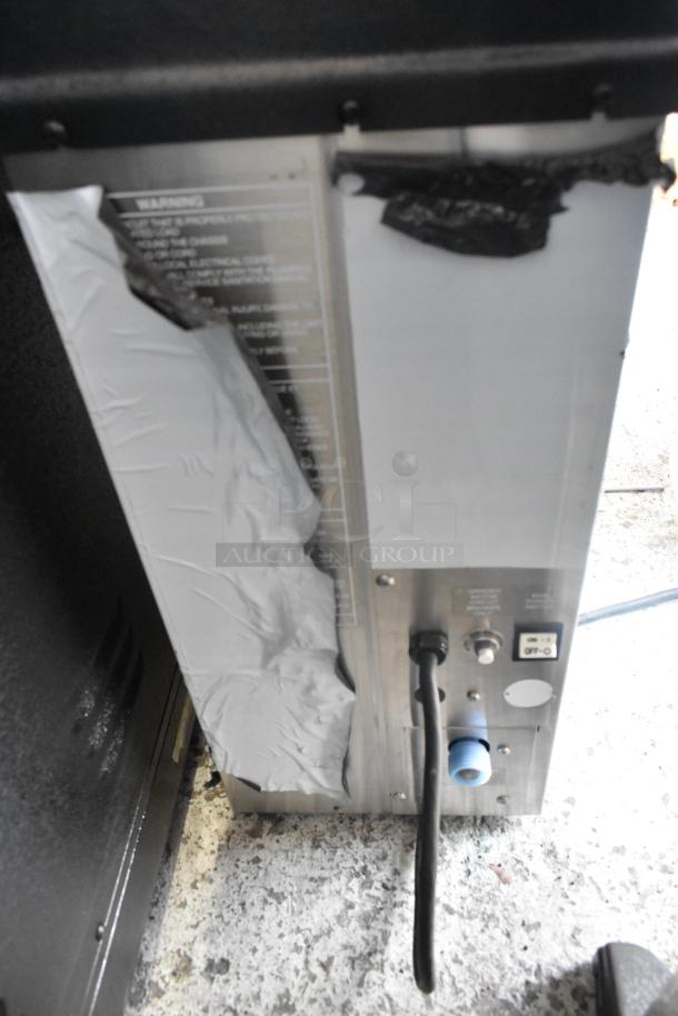 Grindmaster Grind'n Brew-10H commercial coffee maker, showing back panel with power switch and electrical cord. Wear visible.