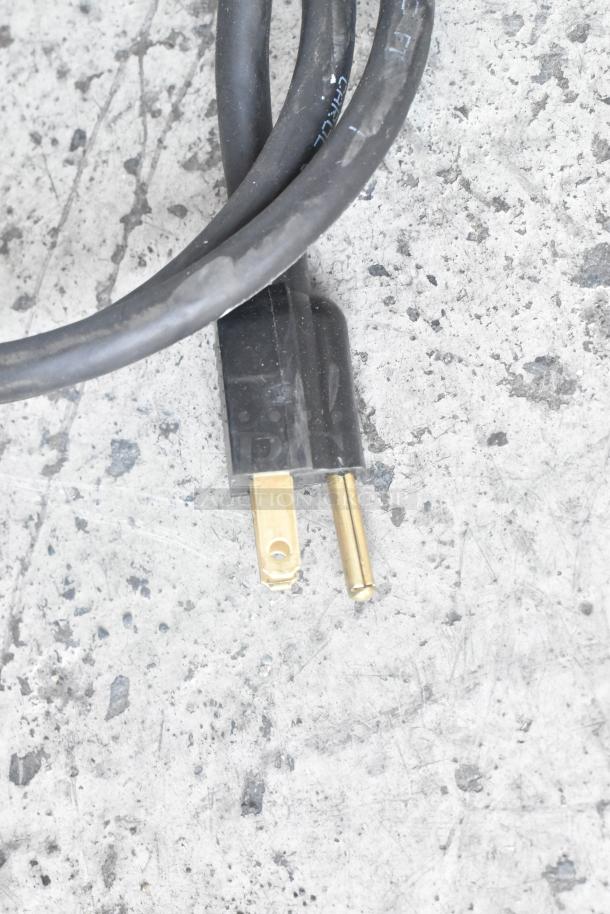 Grindmaster Grind'n Brew-10H coffee maker plug, showing a standard 120V, 1-phase connection on a textured surface.