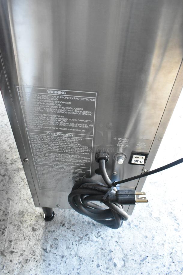 BRAND NEW Grindmaster RGNB-20H stainless steel coffee machine, 120V, with hot water dispenser and metal brew basket. Visible power cord and switch.