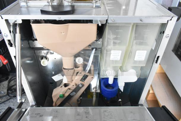 Necta Kolbalto metal commercial countertop espresso machine, open view showing internal components and labeled containers.