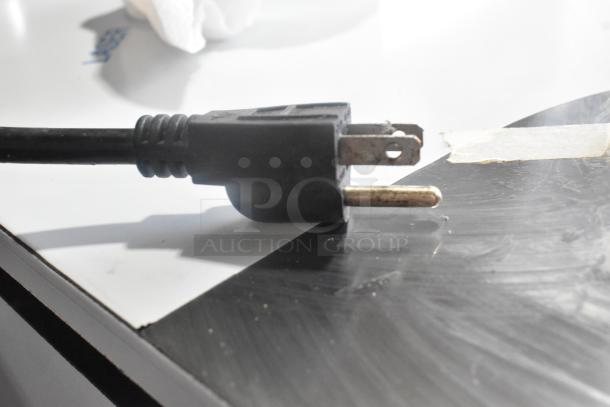 Close-up of a black electrical plug for Avantco MX20 commercial dough mixer, showing pronged design on a reflective surface.
