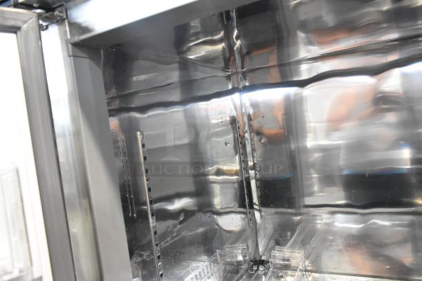 Unique stainless steel commercial 4 half-size door reach-in cooler/freezer, 115 volts, on casters, interior view.