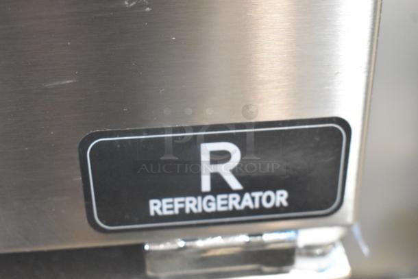 Unique stainless steel commercial reach-in cooler label, indicating refrigerator section. Model features four half-size doors.